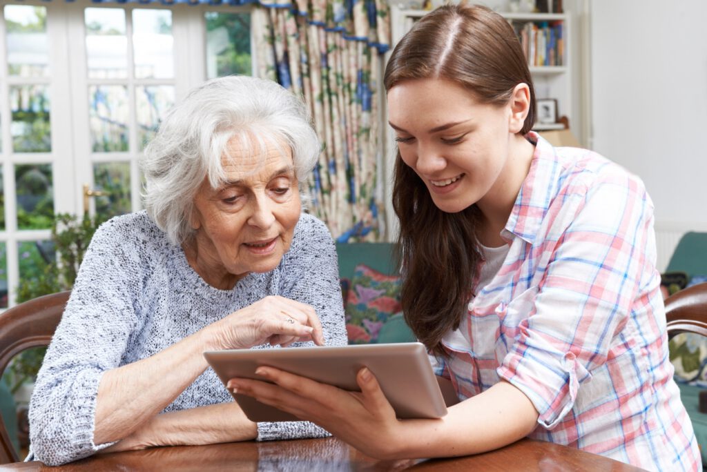 Senior being helped to use an iPad